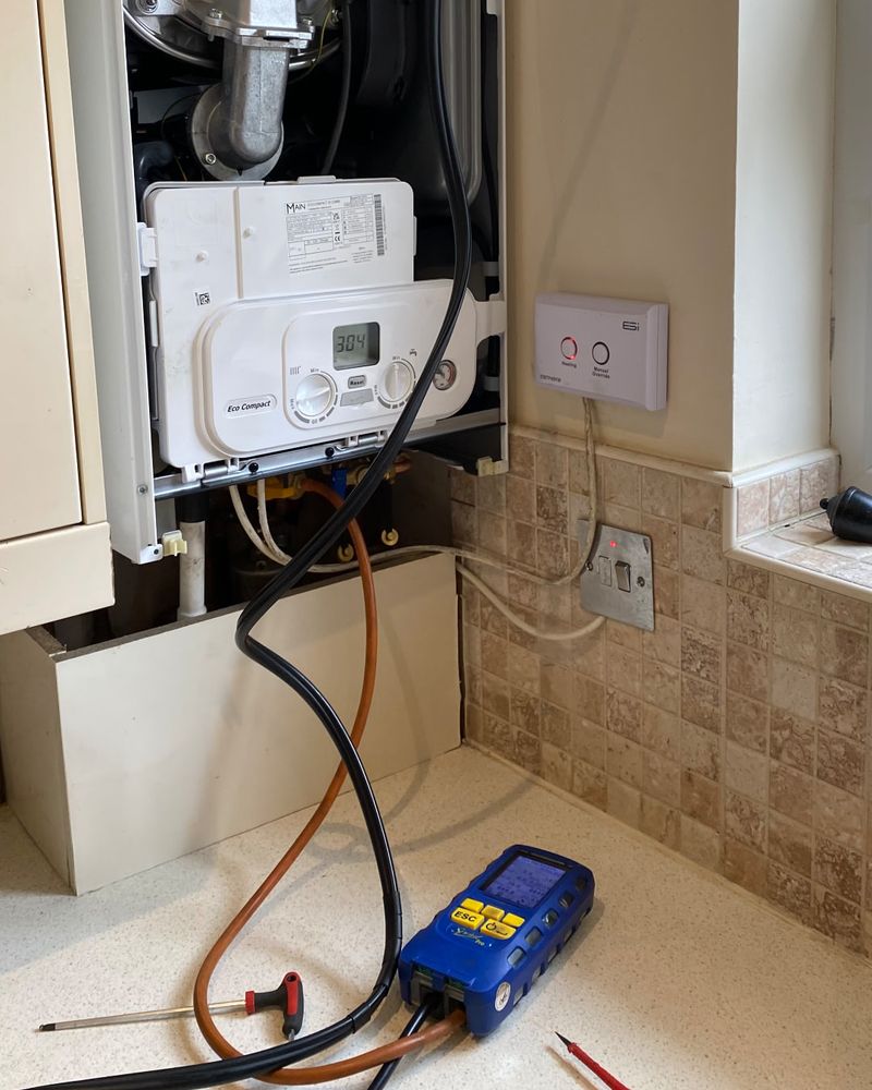 Open combi boiler being checked with a flue gas analyser